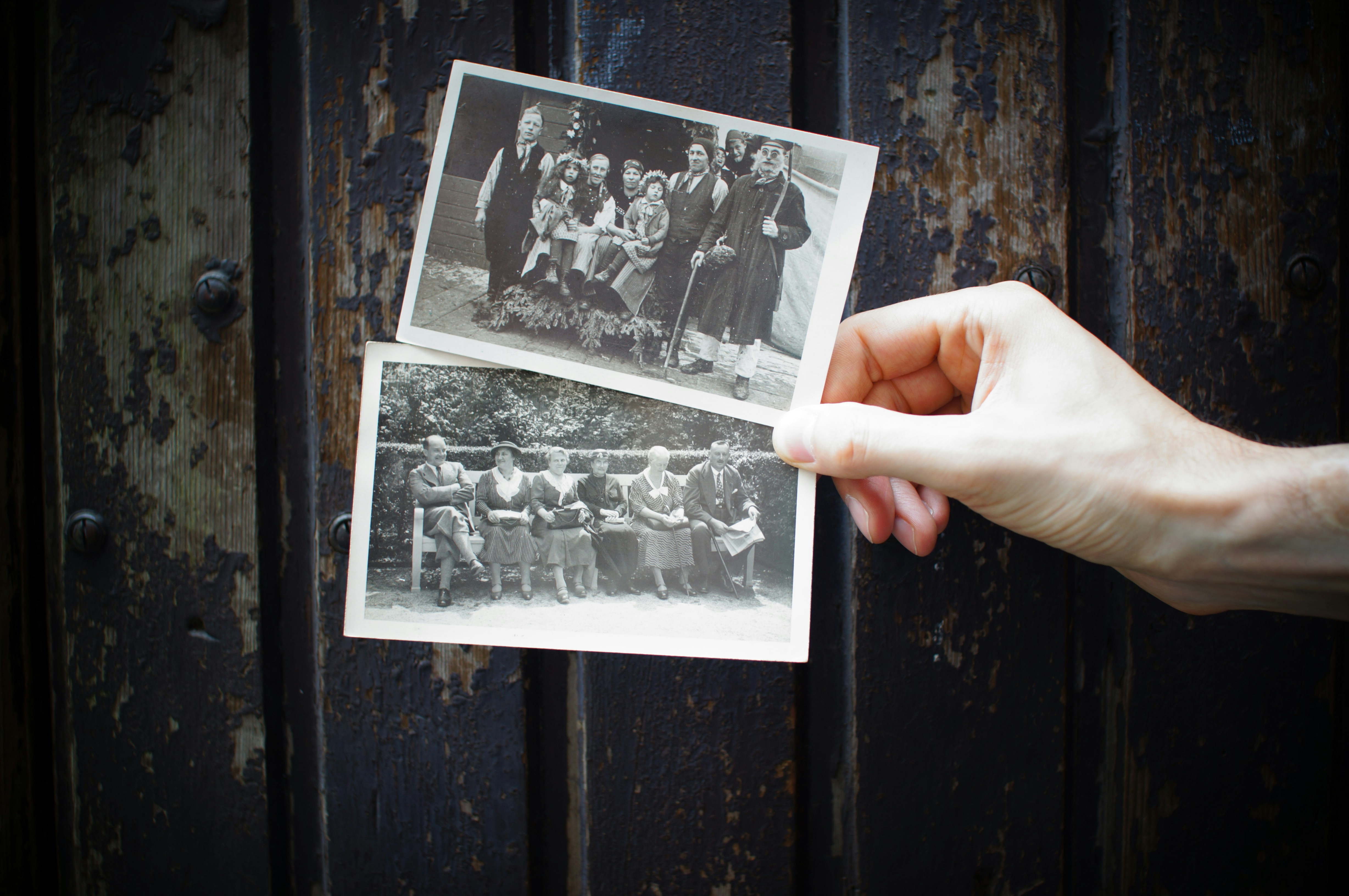 Hand holding two vintage black and white family photographs