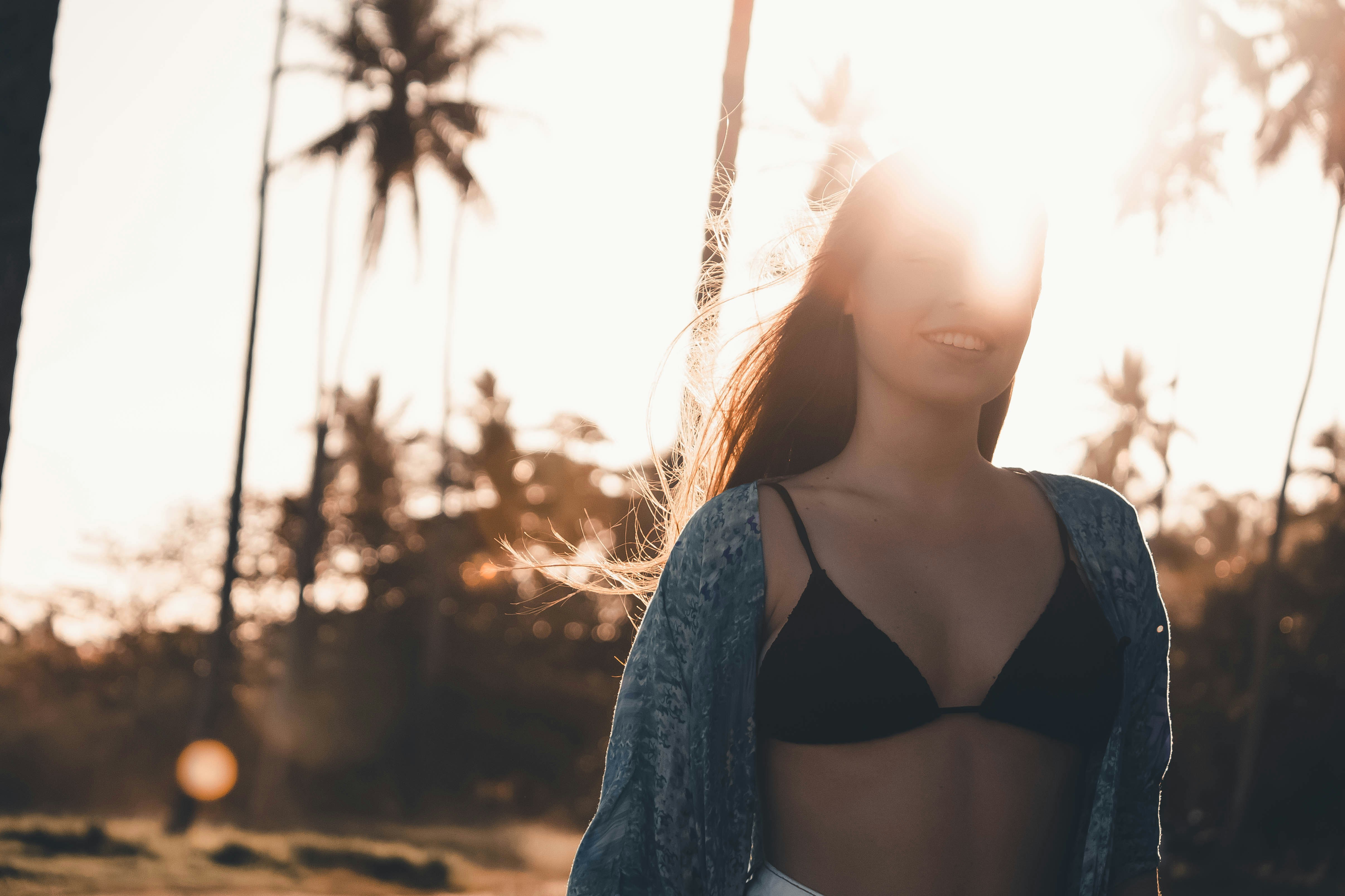 Traveler smiling at sunset with palm trees in the background